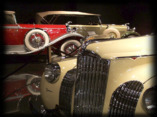 1939 Packard One-Twenty Victoria Convertible with Darrin coachwork and Packard and Lincoln in the background  